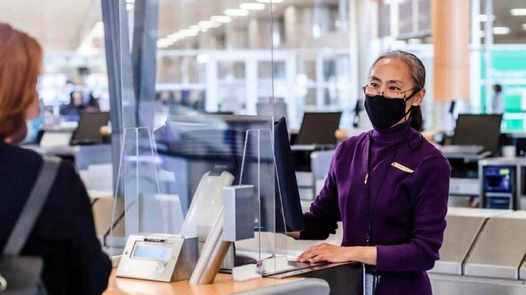 A Delta customer service agent helps a passenger.