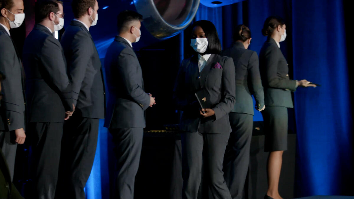 A Delta flight attendant walks off the stage with her new wings.