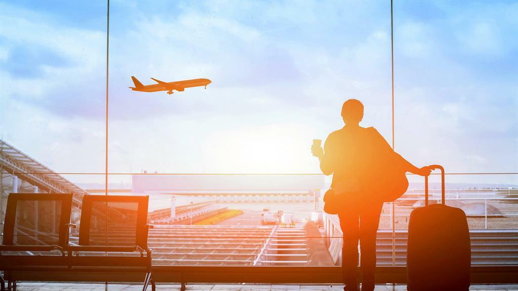 Customer watches plane at sunset