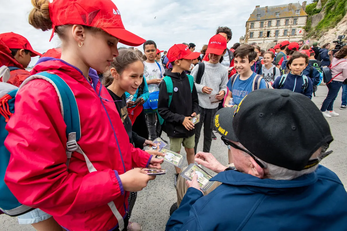 Raymond Dawkins passes his cards out to children at Mont St. Michel.