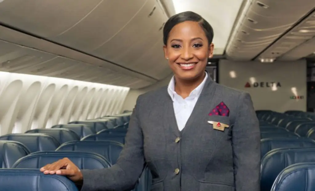 Delta flight attendant in grey uniform onboard aircraft