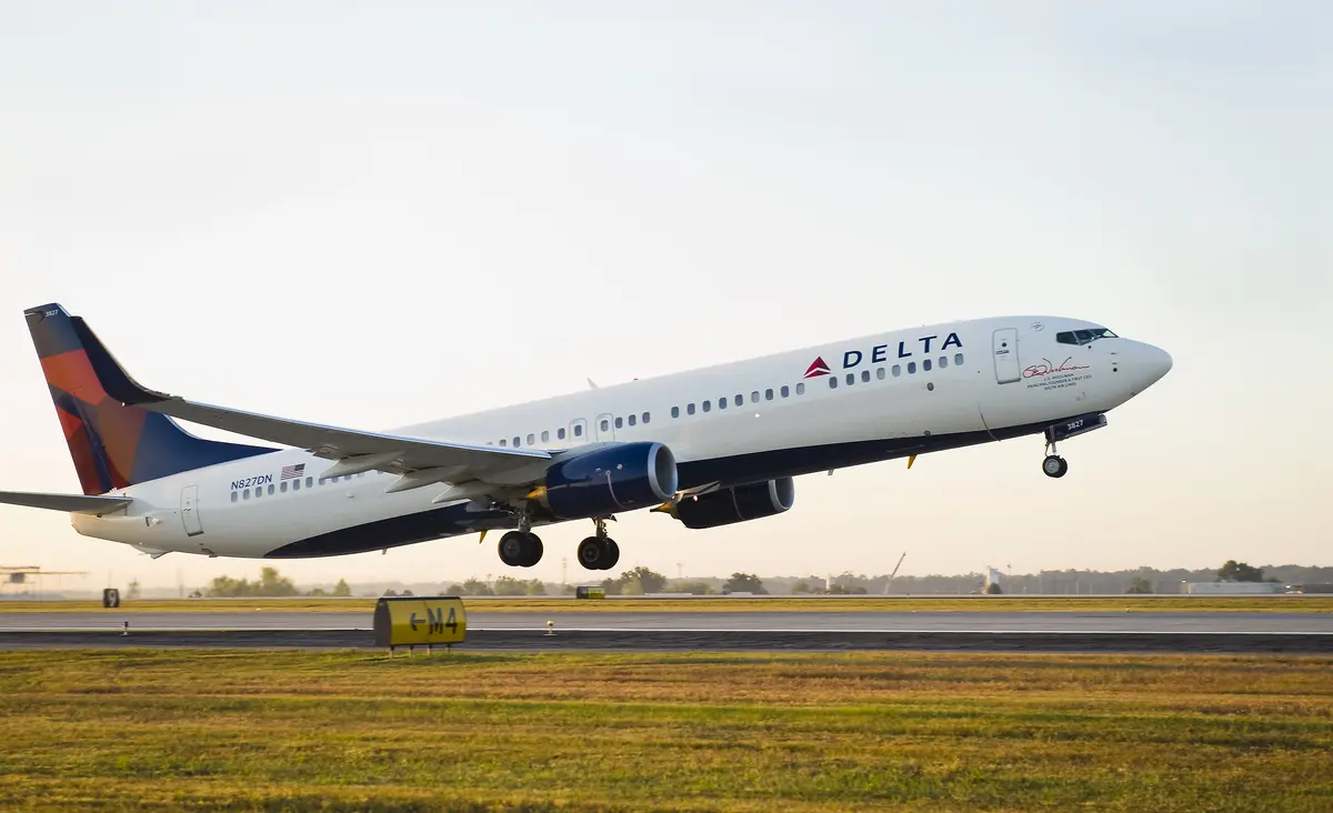 A 737-900 takes off into a clear sky.