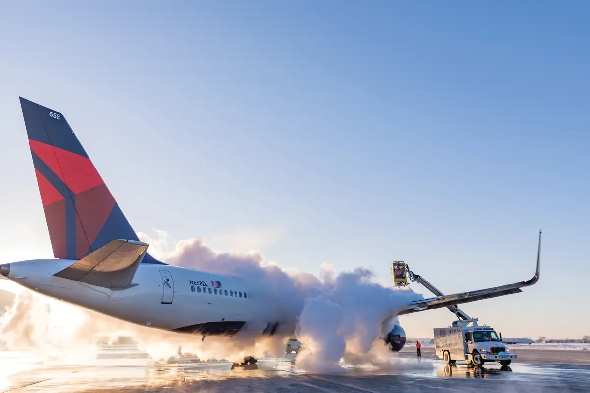 A 757-200 is deiced on a runway.