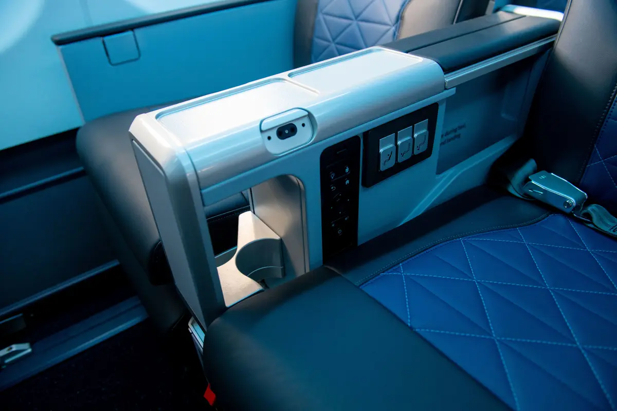 Close up of cupholders, seat controls and armrest for Premium Select aboard the A330-900neo