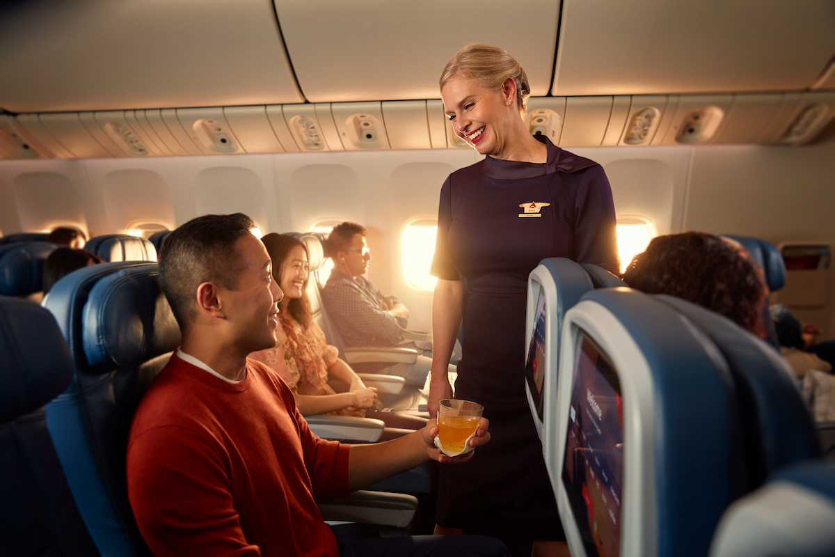 A Delta flight attendant helps a customer on board their flight.