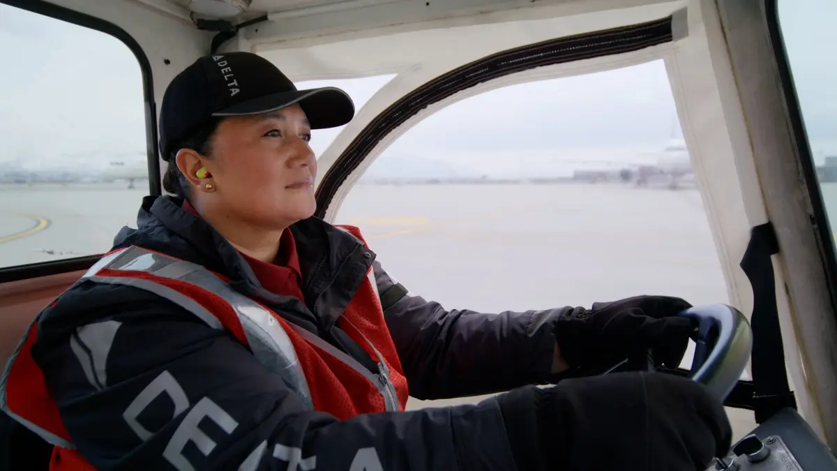 Delta Ramp Agent Sinai Pauni drives an electric bag tractor at Salt Lake City International Airport (SLC).