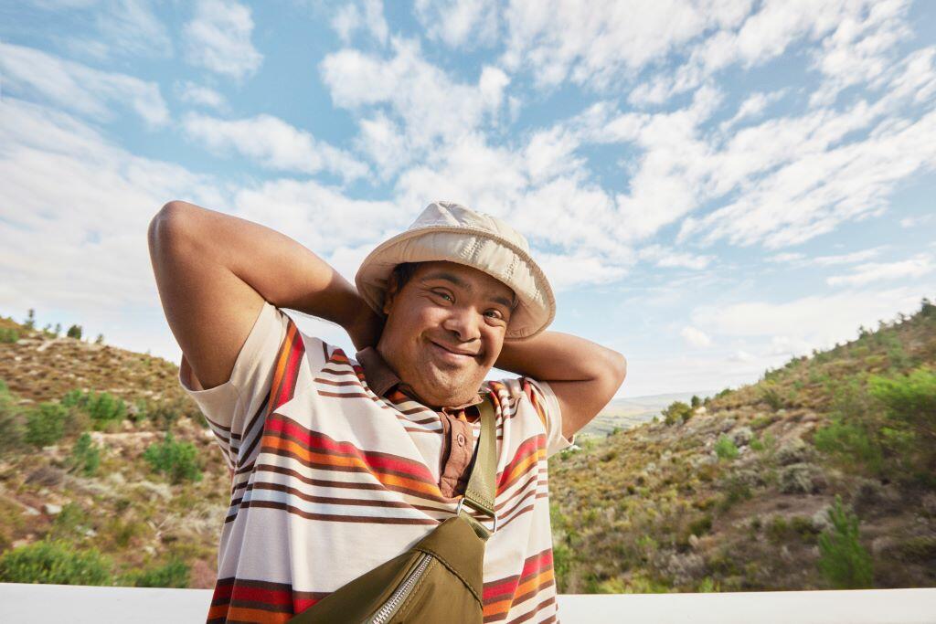 A man smiles with mountains behind him