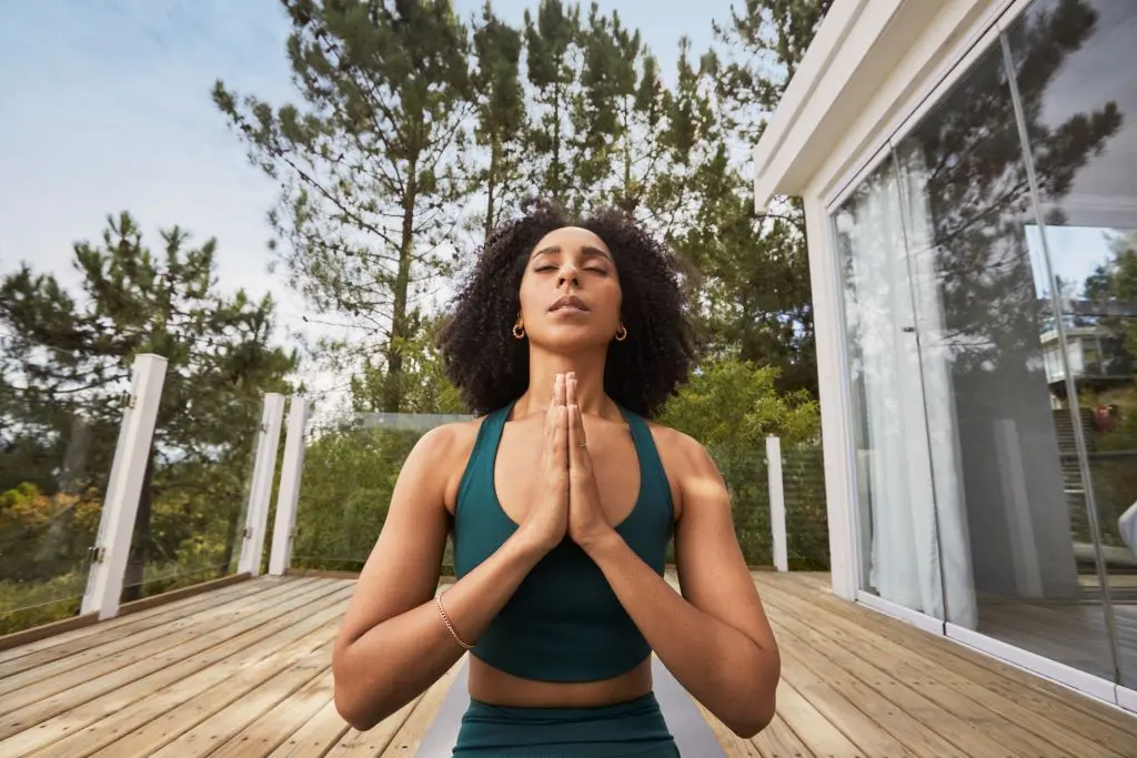 A woman practicing yoga on her back porch