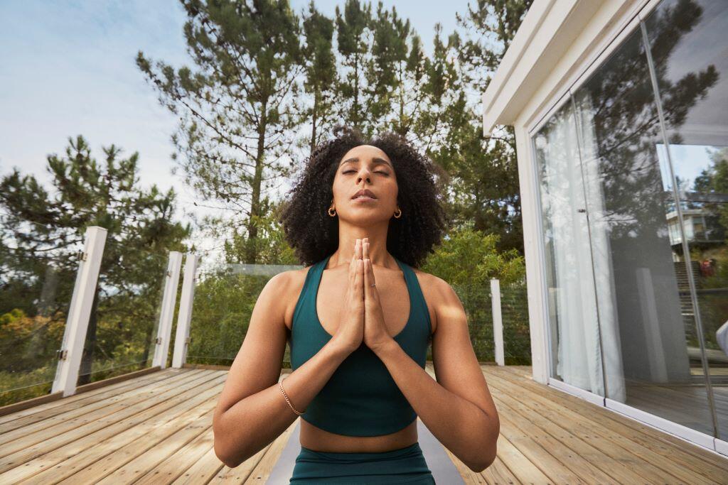 A woman practicing yoga on her back porch