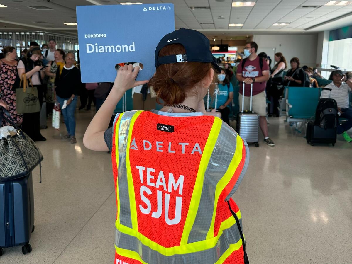 A child holds up a boarding sign at San Juan Airport as part of a special initiative to inspire excitement about aviation. 