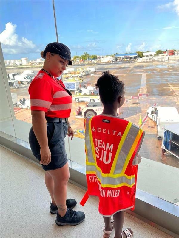 A Delta employee talks to a child at San Juan Airport as part of a special initiative to inspire excitement about aviation.