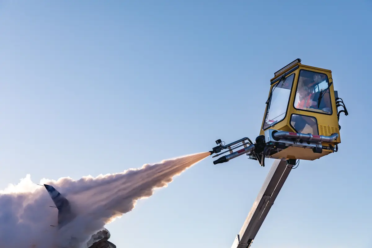 A Delta worker de-ices an airplane at Minneapolis-Saint Paul International Airport.