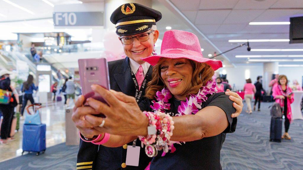 Delta employees pose for a photo before boarding Delta's Breast Cancer One charter