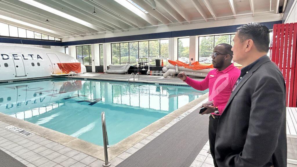 A Delta technical facilitator gives Todd O., Delta's most frequent flyer, greater insight into the rigorous flight attendant training sessions overlooking the emergency diving pool. 