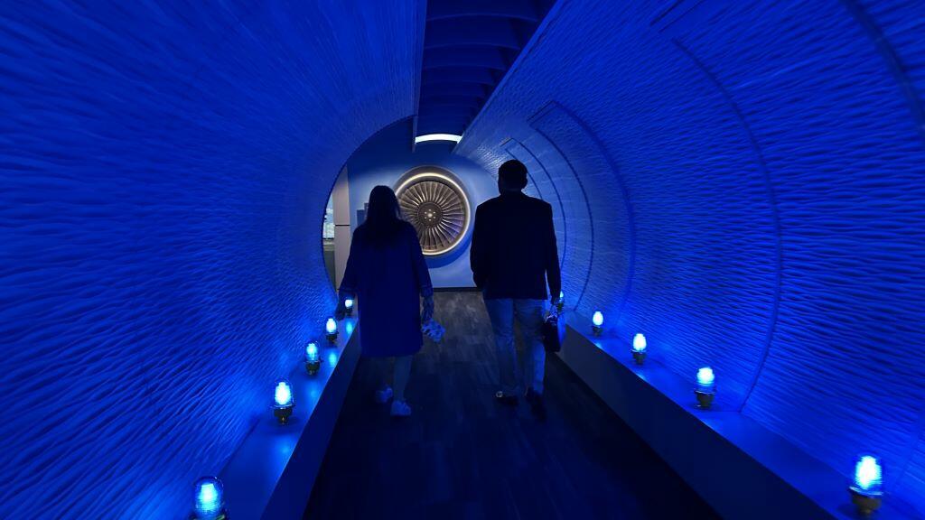 Todd O., Delta's most frequent flyer, and a Flight Museum employee walk through the breezeway before touring the Boeing 767 Spirit of Delta on the other side. 