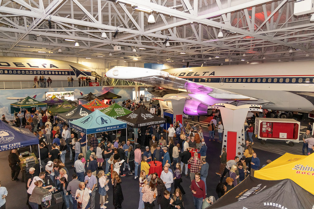 People attend the Hops in the Hangar event in the Delta Flight Museum.