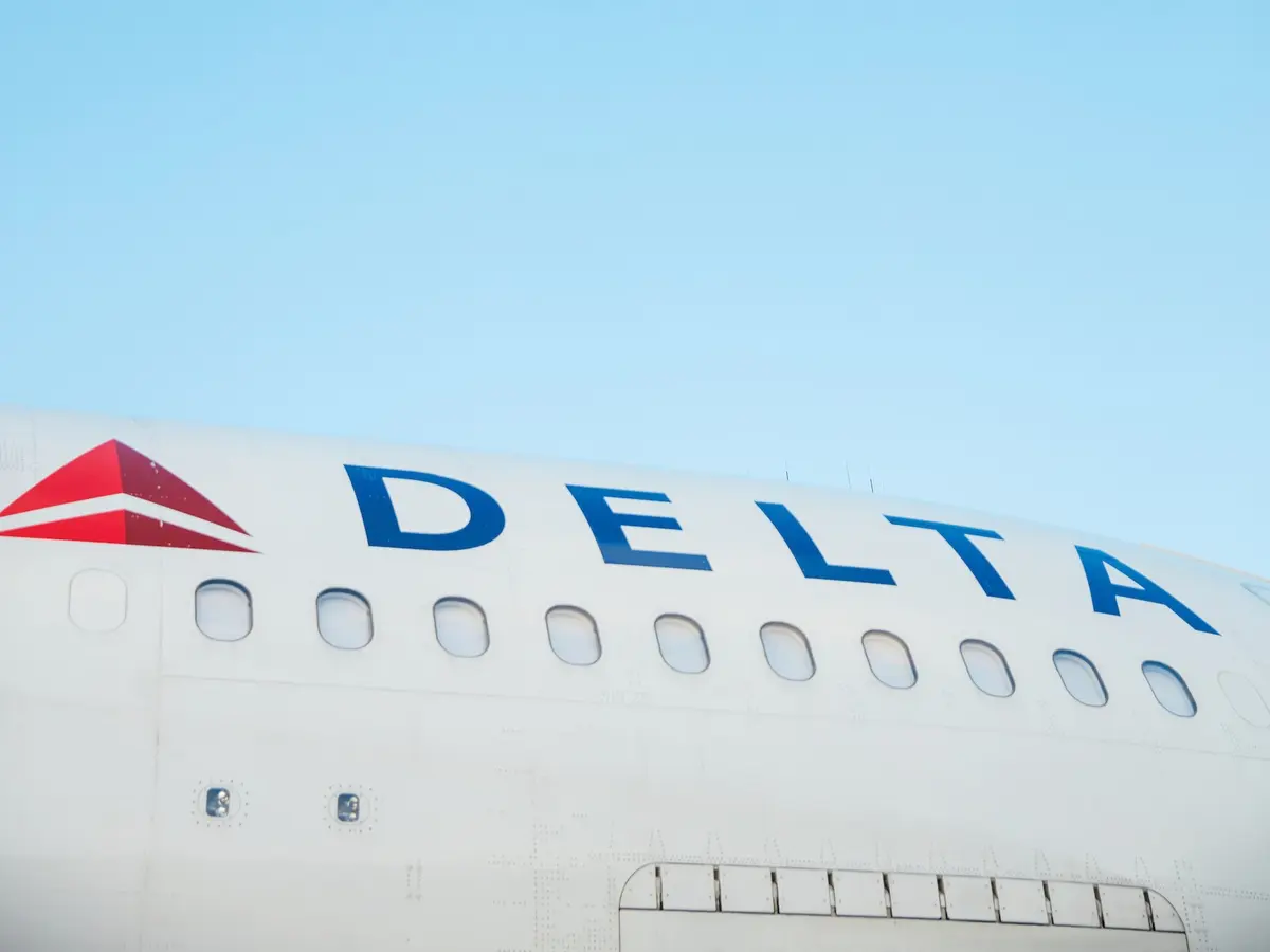The side of a Delta aircraft against a blue sky