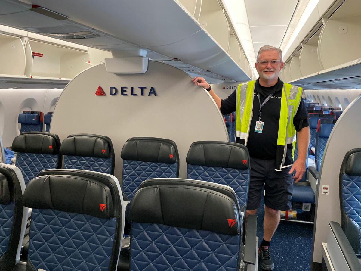 Tracy Rawls, Lead Aviation Maintenance Technician on the Delta TechOps Cabin Maintenance Team, stands on board an airplane.