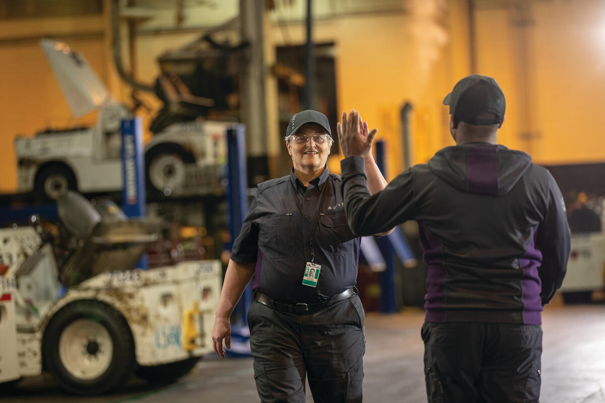 Delta employees high-five at work.