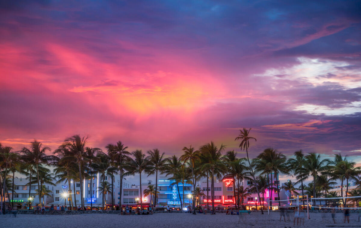 A sunset view of South Beach, Miami, complemented with neon signage and palm trees.