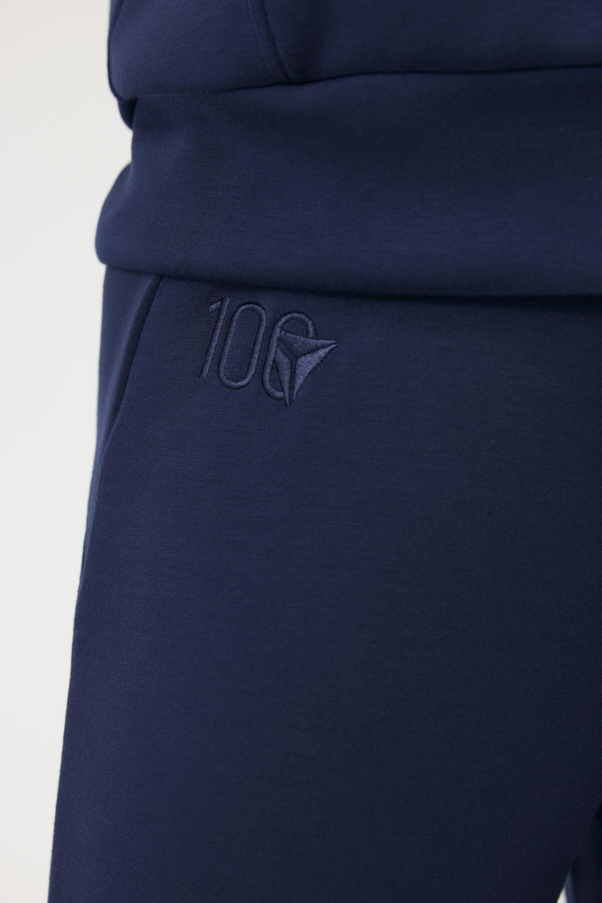 Close up of Delta Centennial logo embroidered on navy wide leg Spanx pants.