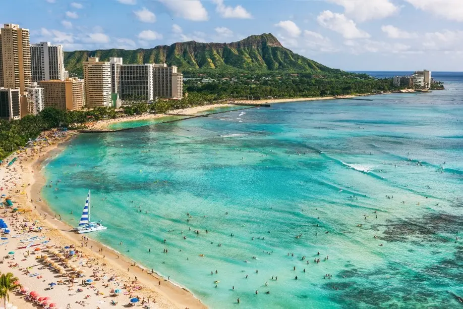 A skyline overlooking a beach and turquoise waters in Hawaii.