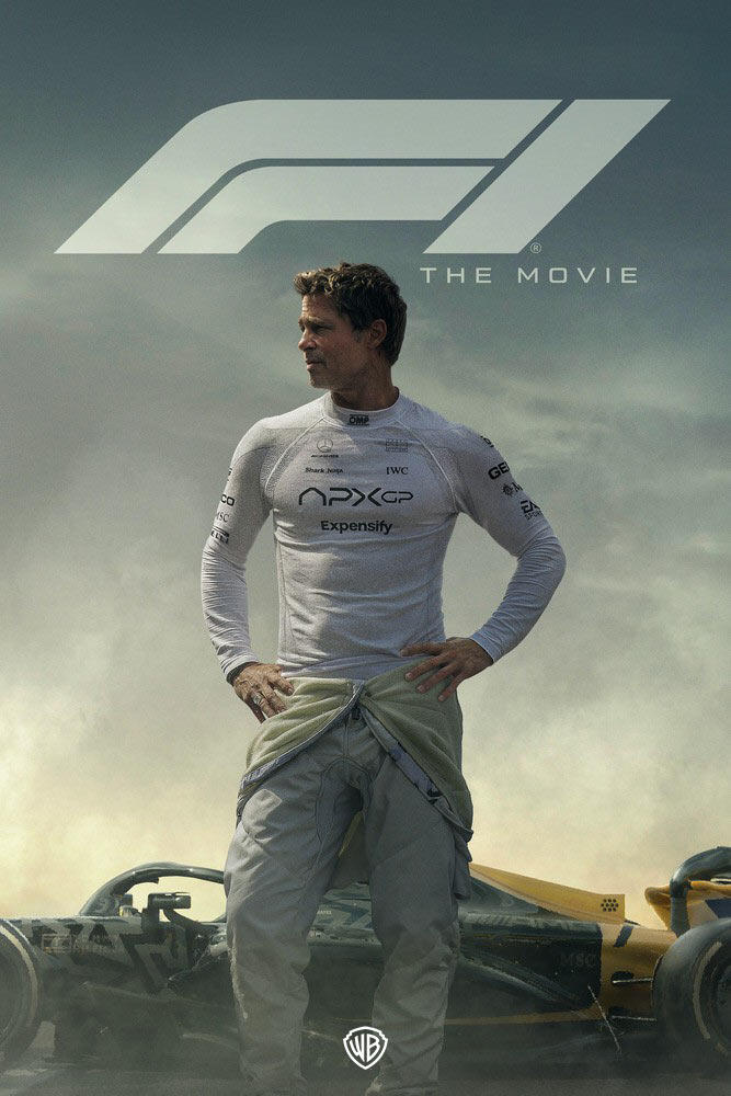 Racing driver in a white fire‑resistant top stands in front of a Formula 1 car amid dust and haze, with a large stylized F1 logo and the words ‘The Movie’ above.