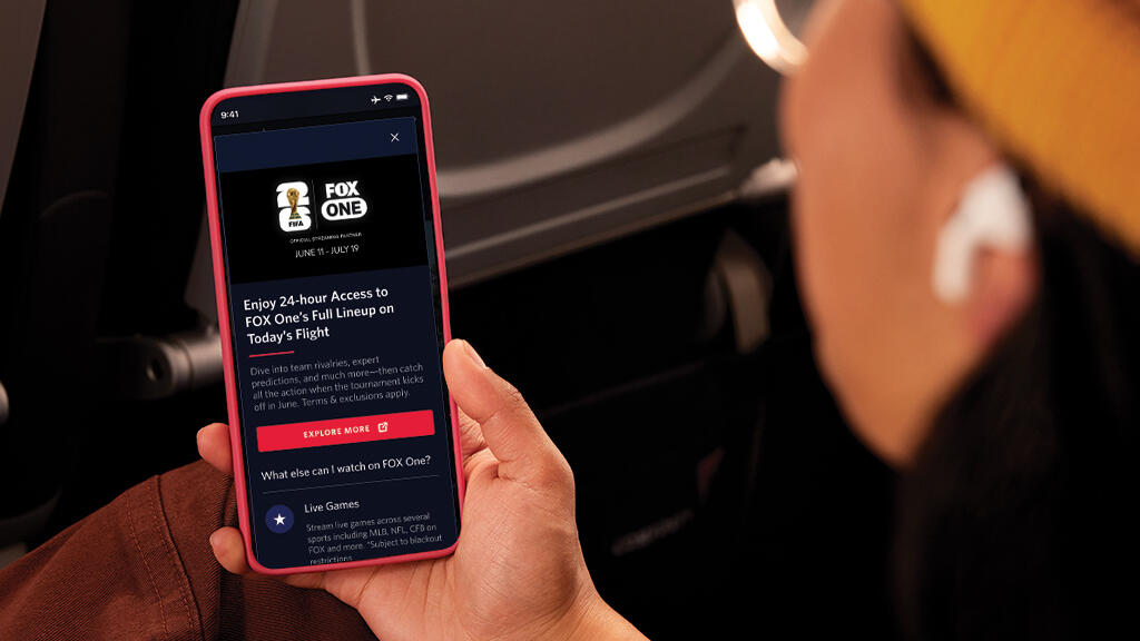 Passenger viewing FOX One content on a smartphone during a flight.