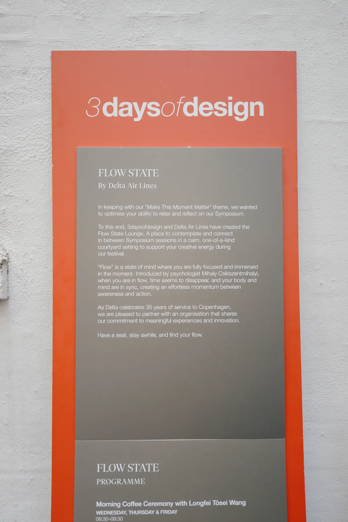 Poster on a wall reading “3daysofdesign” with a “Flow State by Delta Air Lines” description and event program details below.