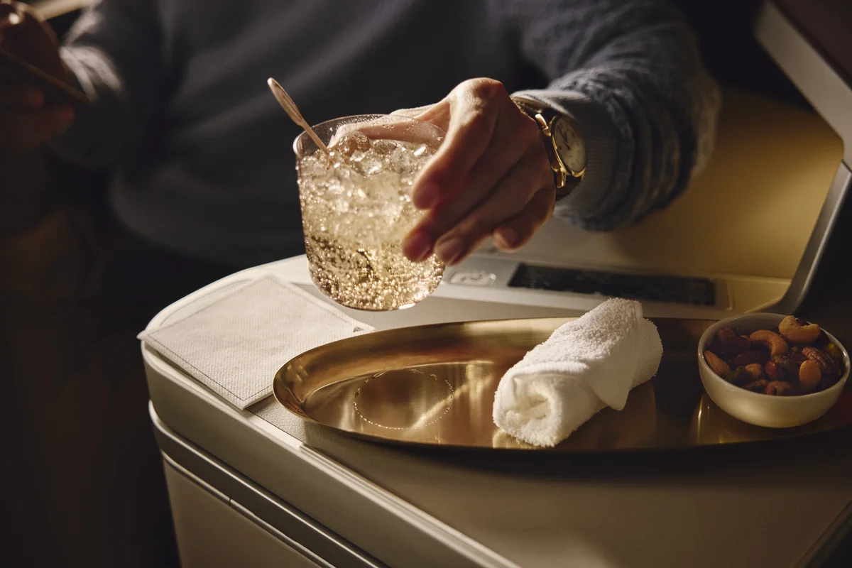 Beverage and mixed nuts served on a tray table in a Delta One suite.