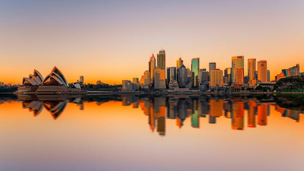 A view of downtown Sydney and the Opera House against a sunrise