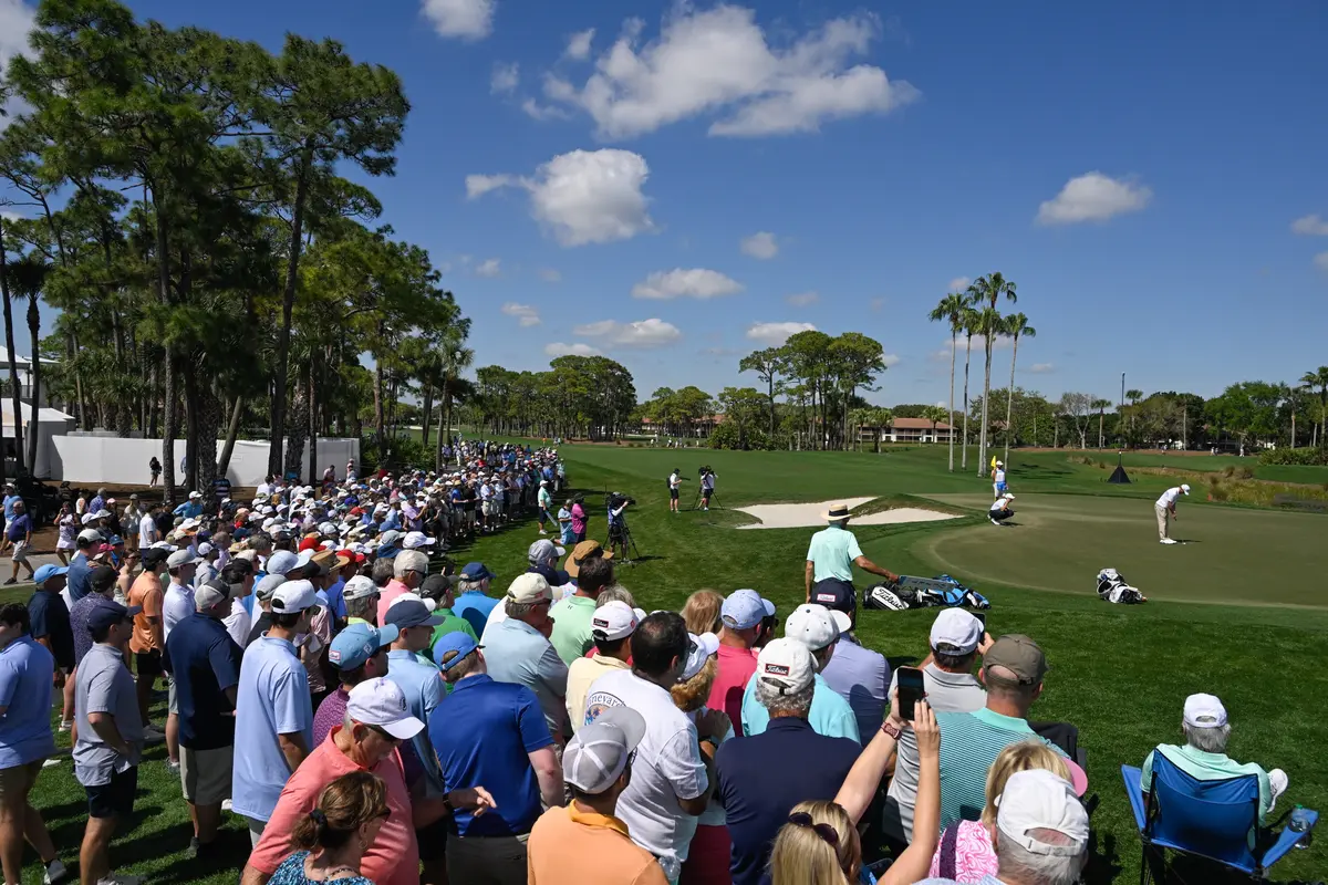 Fans surround a golf green while attending a PGA Tour event.