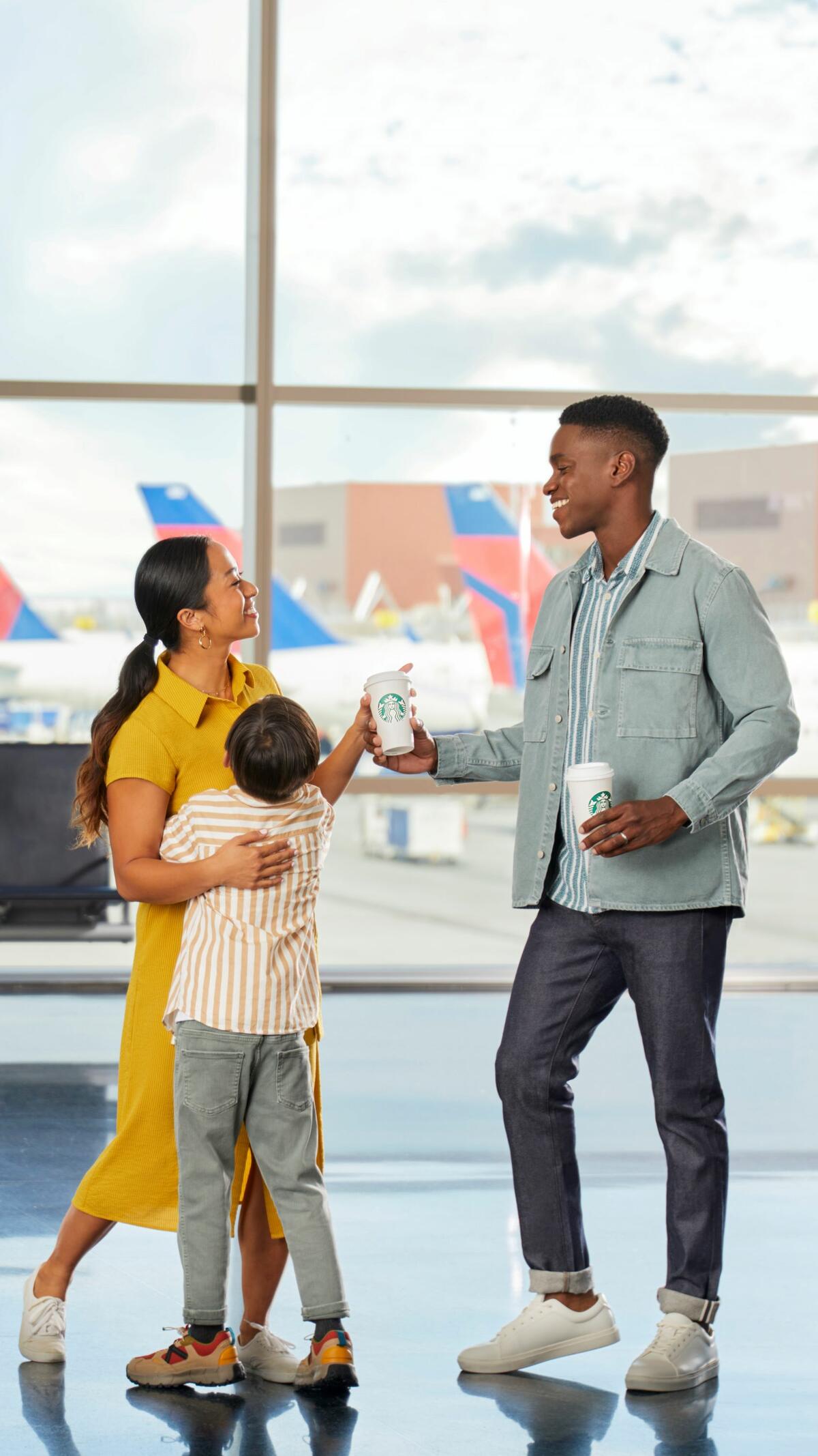 Family group of three enjoying Starbucks at airport