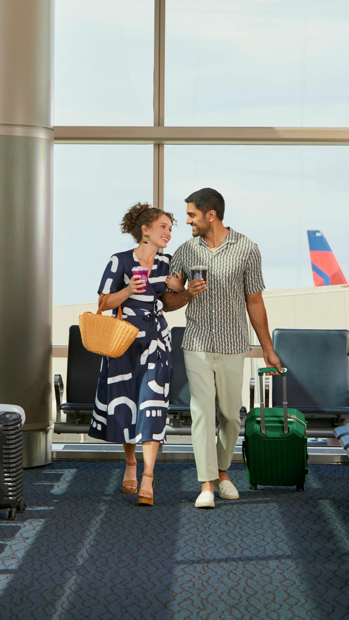 Couple in airport enjoying Starbucks beverages