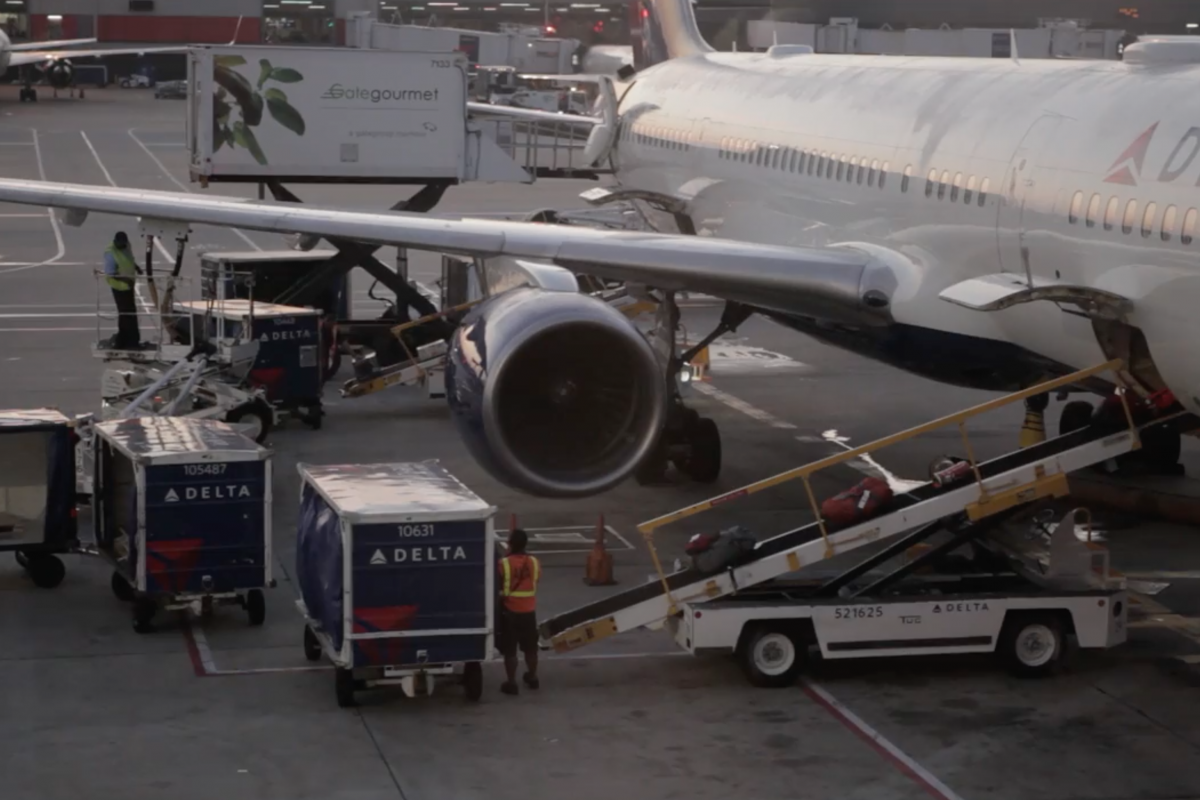 B-roll san juan humanitarian video still image. image of a man loading baggage on to a plane