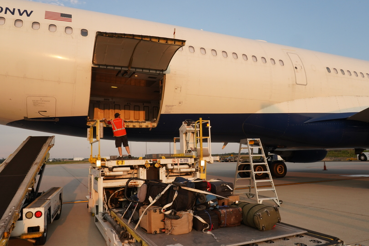 A Delta crew member unloads luggage from a CRAF flight inbound from Afghanistan.