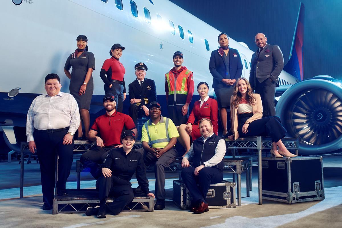 Employees from across Delta's divisions pose in front of a plane in 2023.