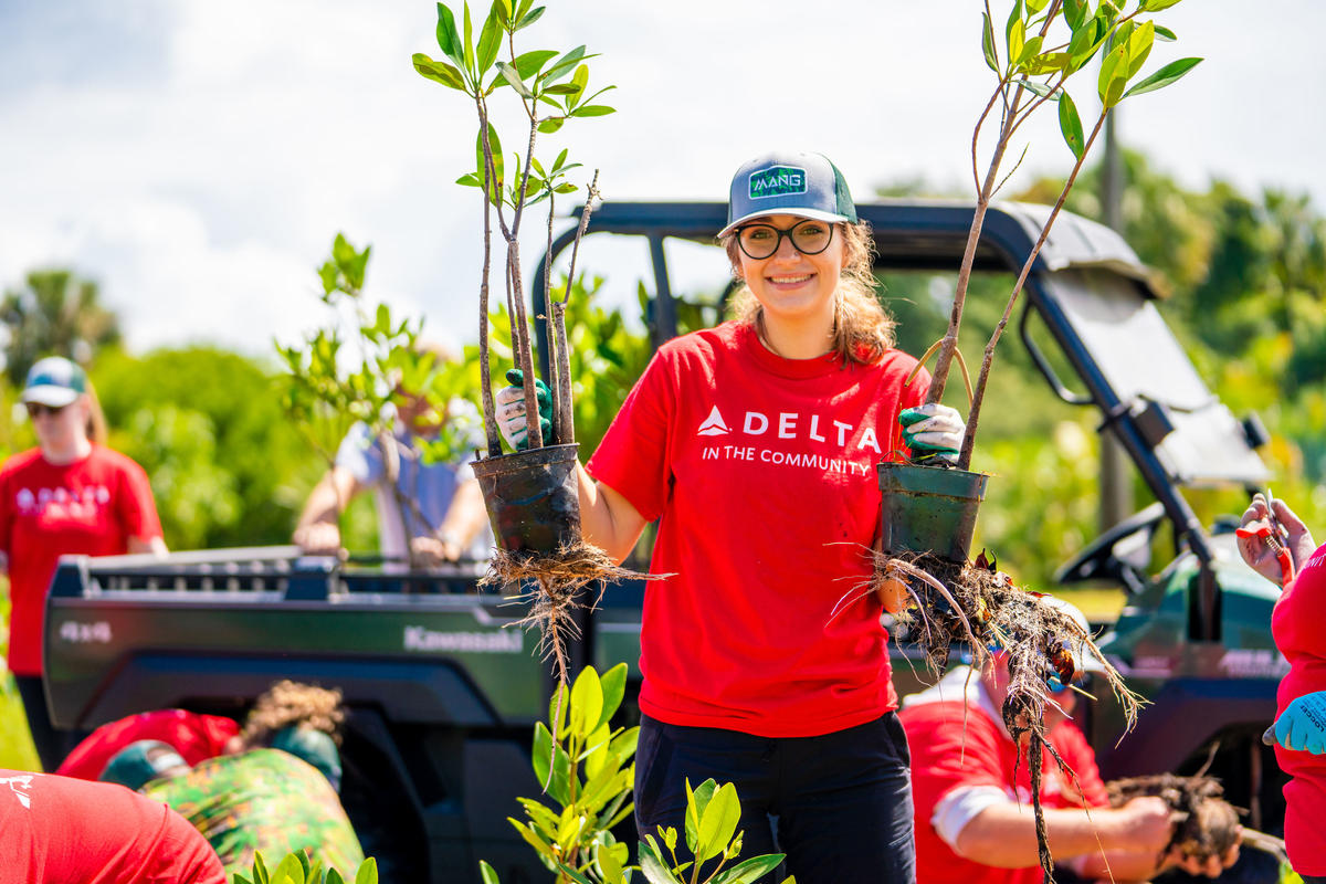 A Delta volunteer holds mangroves.