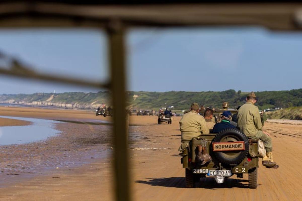 After signing countless autographs, the veterans enjoyed a ride on World War II-era vehicles to Omaha Beach, where they laid roses to remember comrades who lost their lives on those shores.