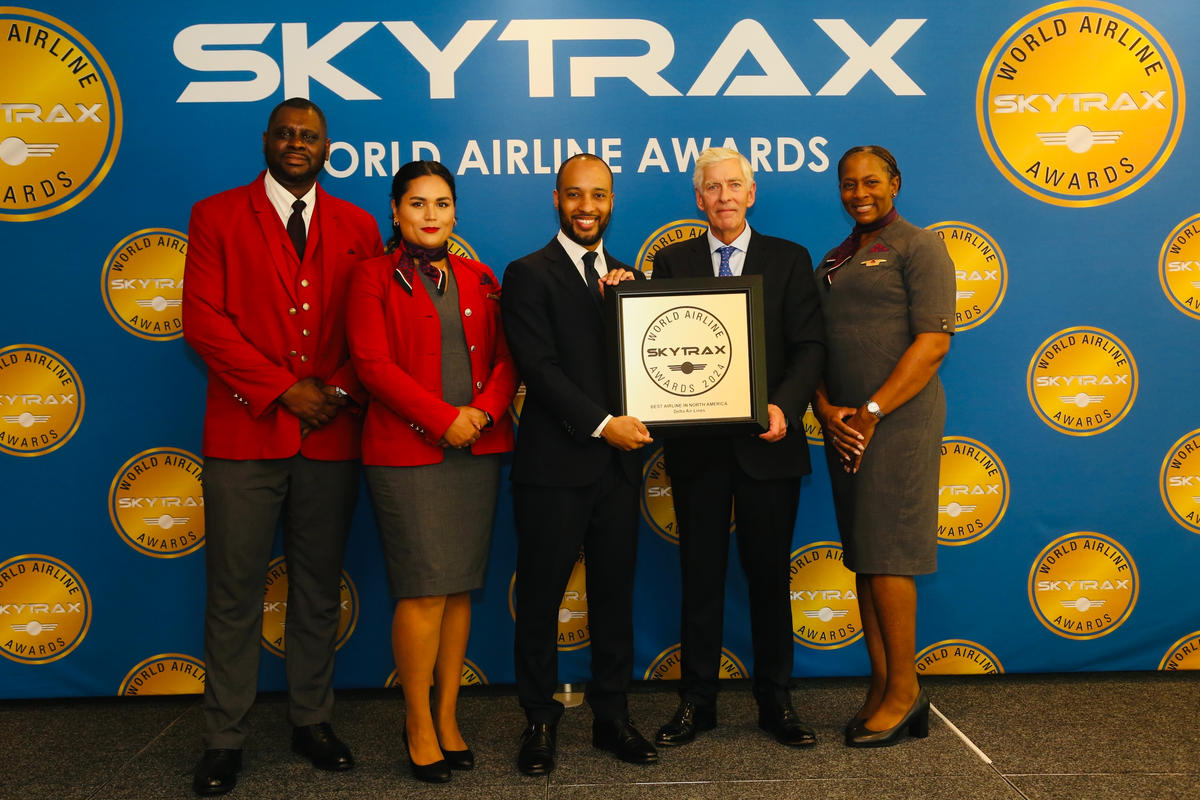 Delta employees accept a Skytrax World Airline Award from Edward Plaisted, the CEO of Skytrax.