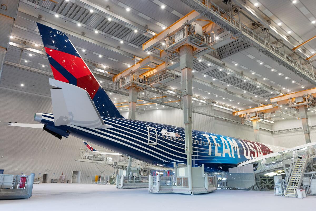 Delta plane with Team USA livery parked in a well-lit hangar.
