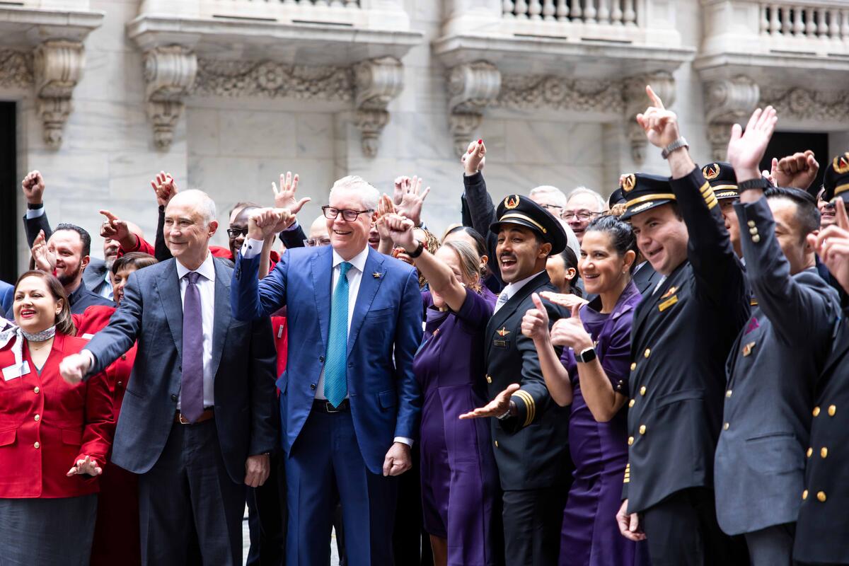 Group photo of Ed and Delta employees cheering outside of the NYSE building