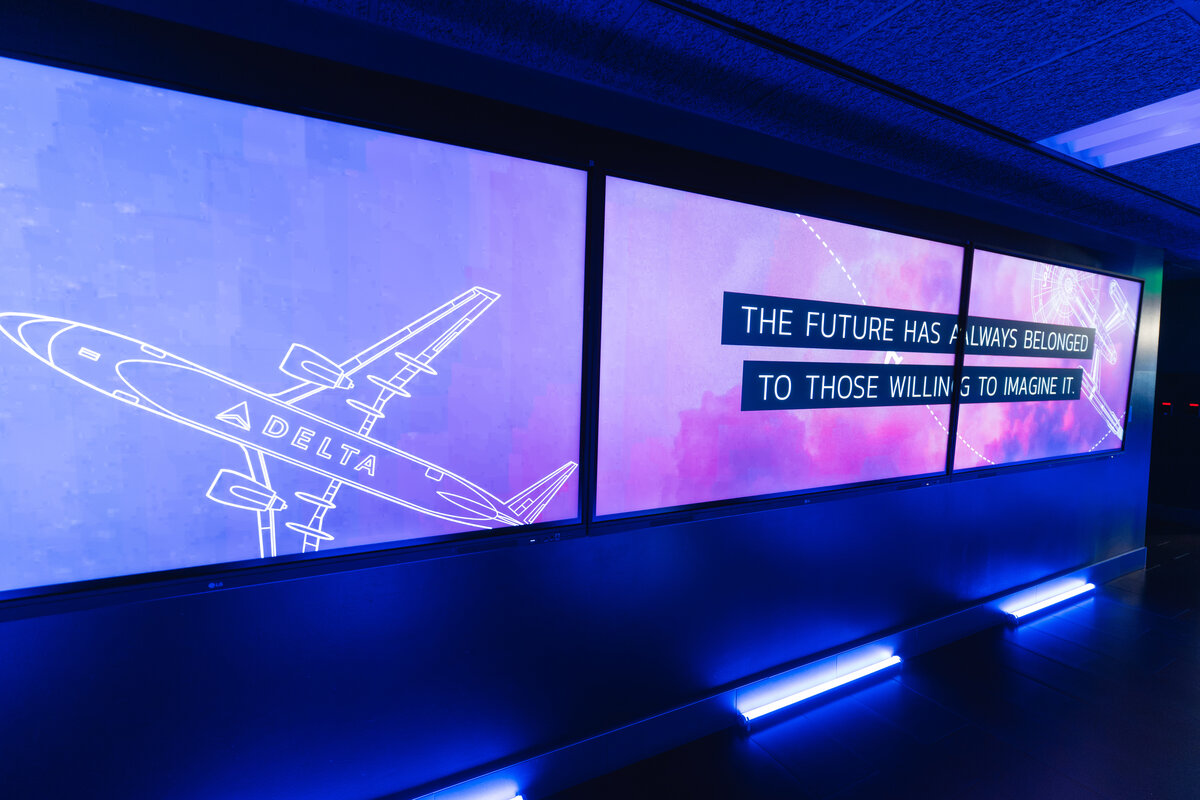 Immersive digital hallway featuring Delta aircraft graphics and a space-themed message wall.
