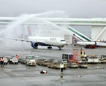 Greeted by a water turret salute, the Airbus A330-900neo touched down in Seattle just as the sun rose over the 85-foot-high aerial walkway at IAF, the largest in the world over an active taxi lane. 