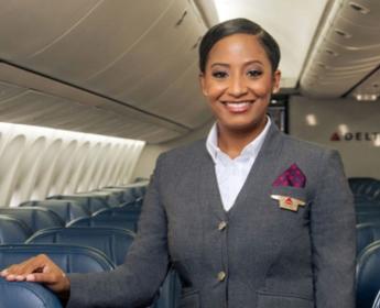 Delta flight attendant in grey uniform onboard aircraft