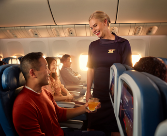 A Delta flight attendant helps a customer on board their flight.