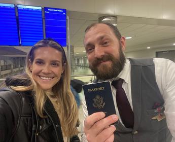 Lawryn Fellwock poses with Delta flight attendant Dusty Dills -- holding the passport she left behind on her honeymoon trip.