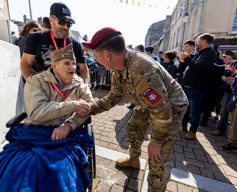 A World War II veteran is greeted by an Army Ranger in Normandy in June 2023.