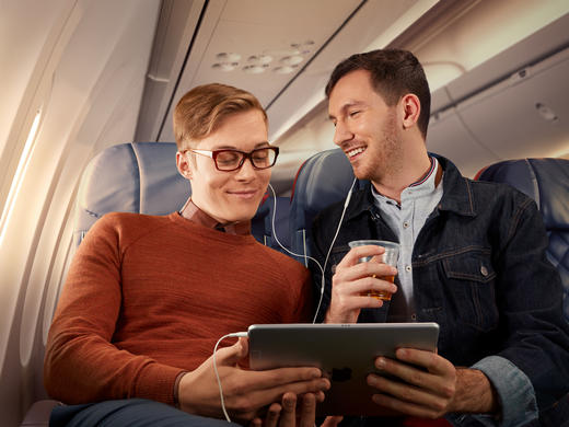 Two people use a table while seated in Delta Comfort+.